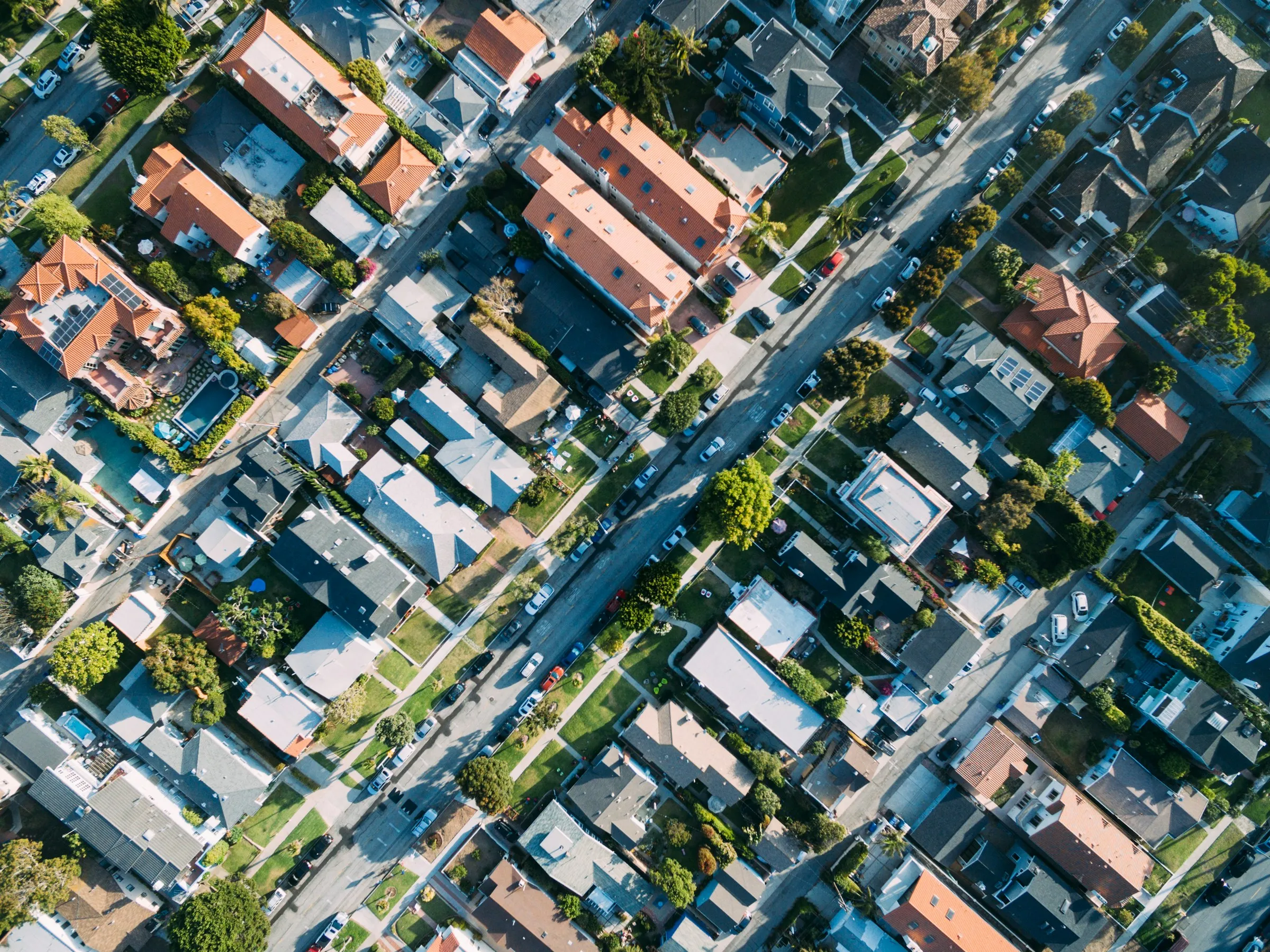 Aerial view of a neighborhood of homes and buildings along tree-lined streets